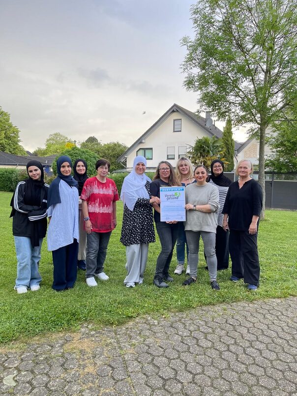 Bild des Vorstands und Übungsleiterinnen des Vereins Ghost in Troisdorf. Sie stehen in einer Gruppe zusammen und halten das Zertifikat "Verein.t.gesund" in den Händen
